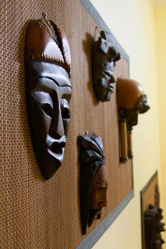 a group of masks hanging on a wall at Auberge Jeunesse à Loulou in Lévis