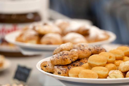 a plate of donuts and other pastries on a table at Hotel Mignon Riccione Fronte Mare in Riccione