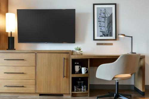a desk with a television and a chair in a room at Hyatt Place Fort Worth/TCU in Fort Worth