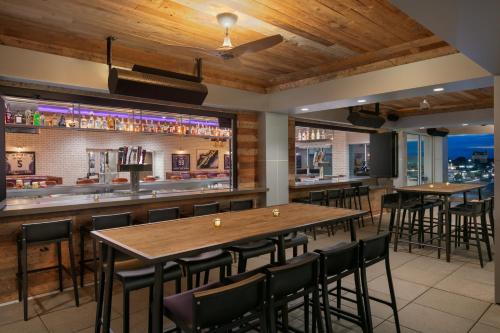 a bar with wooden ceilings and tables and chairs at Hyatt Place Fort Worth/TCU in Fort Worth