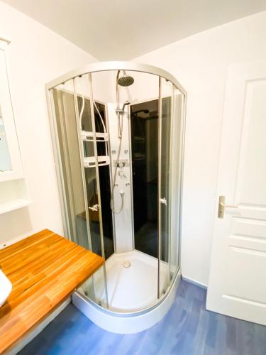 La salle de bains est pourvue d'une douche en verre et d'un sol bleu. dans l'établissement Atypique Chalet la rivière sous votre fenêtre, à Plésidy