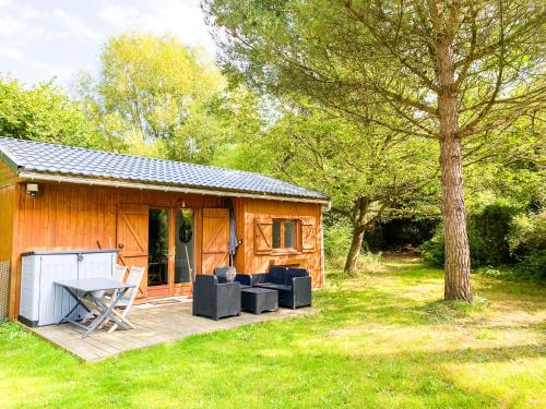 una cabina con tavolo e sedie su una terrazza di Atypique Chalet la rivière sous votre fenêtre a Plésidy