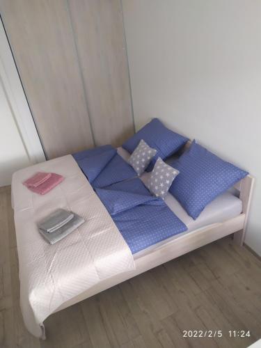 a bed with blue and white blankets and pillows at Krásny byt s výhľadmi v historickom centre in Bratislava