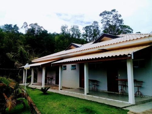 a house with tables and chairs in a yard at Hotel Pousada Riacho da Areia in Águas de Lindóia