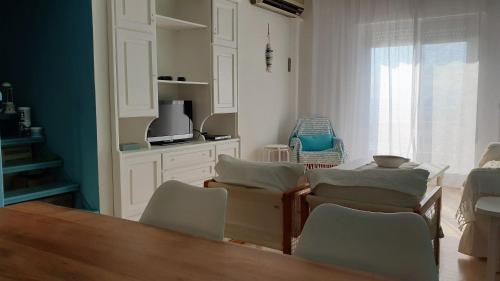 a room with a table and chairs and a kitchen at Alma Maisonette in Kavala