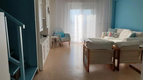 a room with a couch and chairs and a window at Alma Maisonette in Kavala