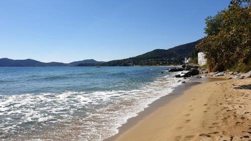 a beach with the ocean and mountains in the background at Alma Maisonette in Kavala