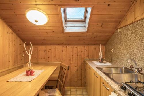 a kitchen with wooden walls and a sink and a window at Appartamento mansardato in San Martino in Badia