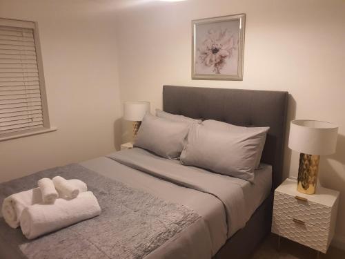 a bedroom with a bed with two towels on it at The Joyland House in Romsey