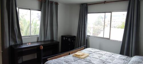 a bedroom with a bed and two windows at Mondrian Santiago in Santiago