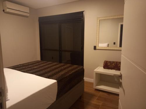 a hotel room with a bed and a mirror at Casa 500 metros do mar in Florianópolis