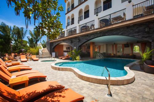 un hotel con piscina y tumbonas en The Hotel Zamora en St Pete Beach