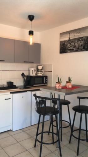une cuisine avec trois chaises et une table dans l'établissement Raphael 20, à Toulon