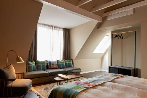 Central Hotel Münster في مونستر: غرفة نوم بسرير واريكة ونافذة