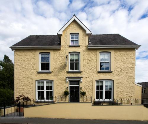 una gran casa de ladrillo amarillo con techo negro en Riverbank Bed and Breakfast, en Llanwrtyd Wells