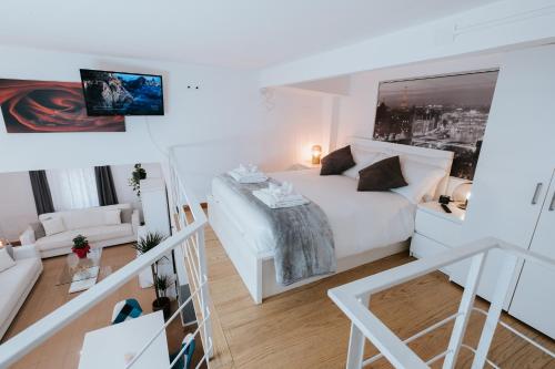 a bedroom with a white bed and a living room at Bruno Domus Trastevere in Rome