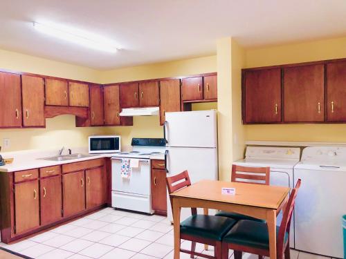 a kitchen with wooden cabinets and a table and a refrigerator at Classic Suites - Cleveland in Cleveland