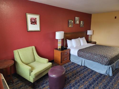 a hotel room with a bed and a chair at Olympic Inn & Suites Port Angeles in Port Angeles