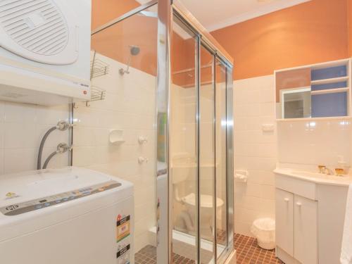 een badkamer met een douche, een toilet en een wastafel bij Charvel 1 35 Gippsland Street in Jindabyne