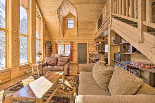 a living room with a couch and a table at Sunny Forest Cabin with Views of Pikes Peak Mtn! in Florissant