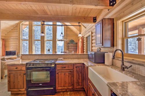 a kitchen with a stove and a sink in a cabin at Sunny Forest Cabin with Views of Pikes Peak Mtn! in Florissant