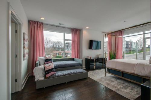 1 Schlafzimmer mit 2 Betten, einem Sofa und einem Fenster in der Unterkunft 4 Connecting Condos - Sleeps 32 to 36 - Firepits - Garages - Rooftops decks - Great Views - Security in Nashville