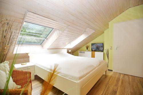 a bedroom with a large white bed with a window at Urlauberdorf Haus 31b in Boltenhagen