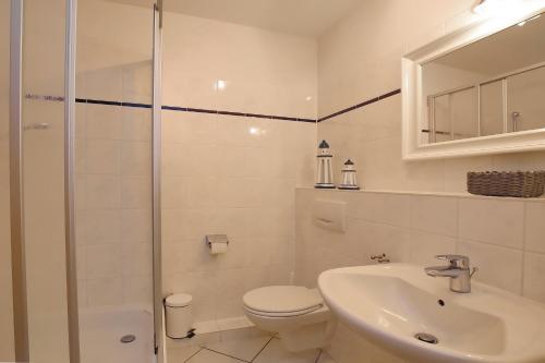 La salle de bains est pourvue de toilettes, d'un lavabo et d'une douche. dans l'établissement Waterkant Wohnung 04 -Promenadendeck, à Boltenhagen
