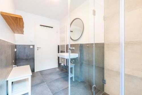 a bathroom with a shower and a sink and a mirror at Strandvilla Meeresblick Wohnung 02 in Boltenhagen