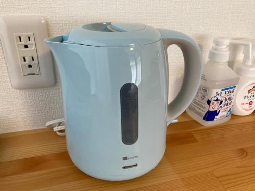 a white electric kettle sitting on a wooden table at Upper Hotel Ishihara in Tokyo