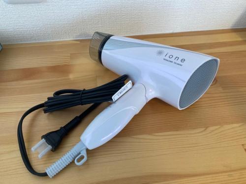 a hair dryer sitting on top of a wooden floor at Upper Hotel Ishihara in Tokyo