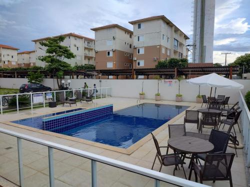 eine Terrasse mit Tischen und Stühlen sowie einem Pool in der Unterkunft Flat com boa localização in Palmas