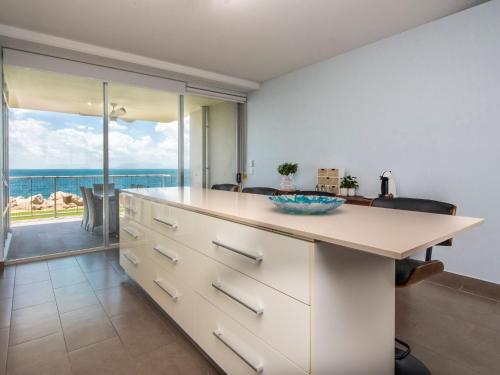 a kitchen with a counter with a view of the ocean at 1 Bright Point Apartment 4105 in Nelly Bay