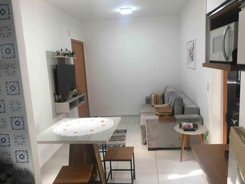ein Wohnzimmer mit einem Sofa und einem Tisch in der Unterkunft Flat com boa localização in Palmas