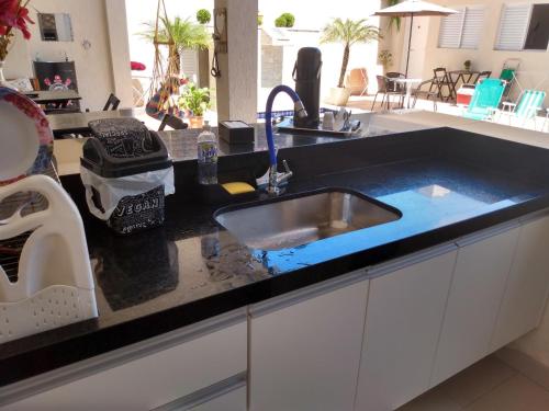 a kitchen counter with a sink with a blue object at Suíte Sanlubia Enseada Guarujá in Guarujá