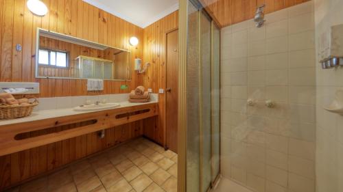 a bathroom with a shower, sink, and tub at Country Roads Motor Inn in Narrandera