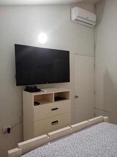 a bedroom with a television on a white wall at Joy Estate Rooftop Pool n View unit #1 in Falmouth