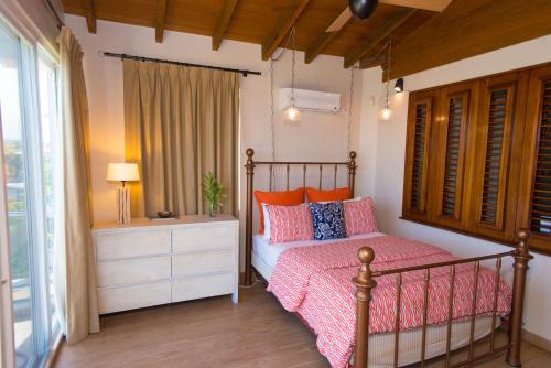 a bedroom with a bed with pink and orange pillows at Marks Reef in Lance aux Épines