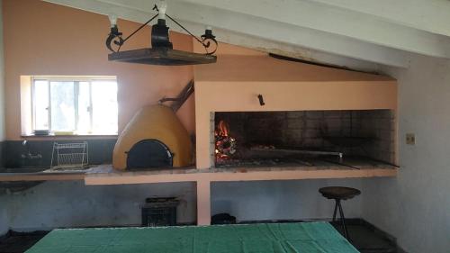 a living room with a fireplace and a stove at Estancia Rincón del San Francisco in Paysandú