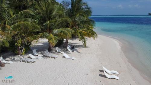 a beach with chairs and palm trees and the ocean at Masfalhi View Inn in Felidhoo