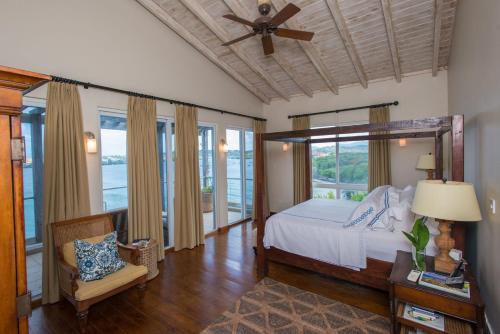 a bedroom with a bed and a ceiling fan at Marks Reef in Lance aux Épines