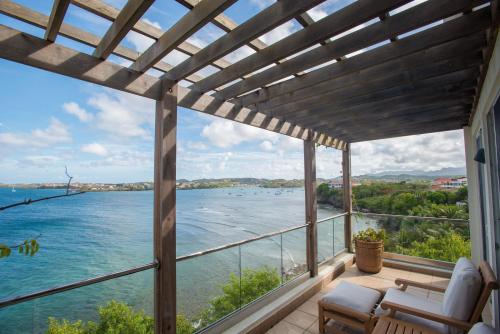a balcony with a view of the water at Marks Reef in Lance aux Épines