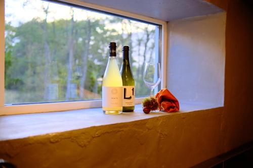 two bottles of wine sitting on a window sill at ヴィラYukara緑屋 in Nanae