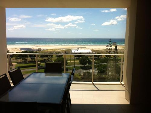 a dining room table with a view of the ocean at Kirra Surf Apartments in Gold Coast