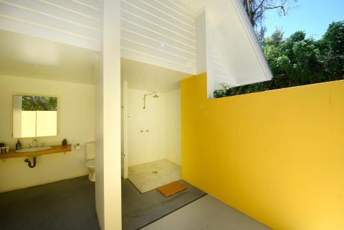 baño con aseo y pared amarilla en Sienna-Rose, en Mission Beach