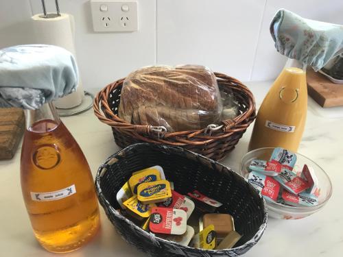 a basket of food sitting on a counter next to a bottle at Winganah Cottage in Murdunna