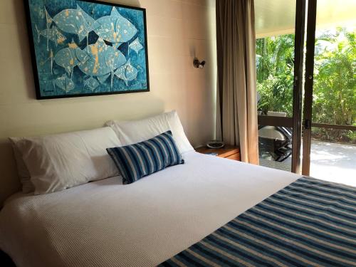 a bedroom with a bed and a large window at Beach-Villa 4 in South Mission Beach