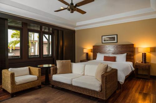 - une chambre avec un grand lit et deux chaises dans l'établissement Berjaya Tioman Resort, à l'Île Tioman