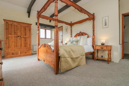 a bedroom with a wooden four poster bed and a table at Marhayes in Camelford