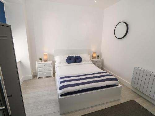 a bedroom with a bed with blue pillows on it at Arlanfor in Rhosneigr